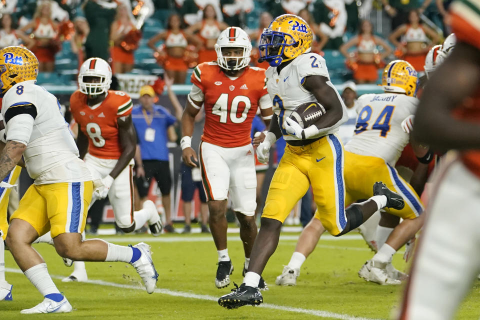 Pittsburgh running back Israel Abanikanda (2) runs past Miami linebacker Caleb Johnson (40) for a touchdown during the first half of an NCAA college football game, Saturday, Nov. 26, 2022, in Miami Gardens, Fla. (AP Photo/Lynne Sladky)