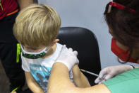 A child receives the vaccination against the COVID-19 virus in Tulln, a city close from Vienna, Austria, Wednesday, Dec. 1, 2021. Austria’s lockdown has officially been extended until Dec. 11 as planned amid signs that the measures are helping to bring down a sky-high coronavirus infection rate. A parliamentary committee signed off Tuesday on the extension of the country’s fourth national lockdown of the pandemic that started on Nov. 22. (AP Photo/Lisa Leutner)