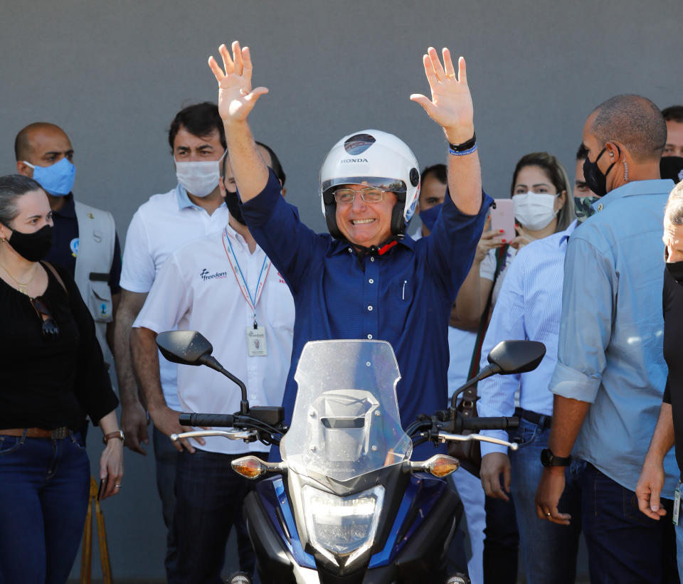 El presidente de Brasil, Jair Bolsonaro, saluda luego de pasear en moto por Brasilia, el 25 de julio de 2020 (AFP | Sergio Lima)