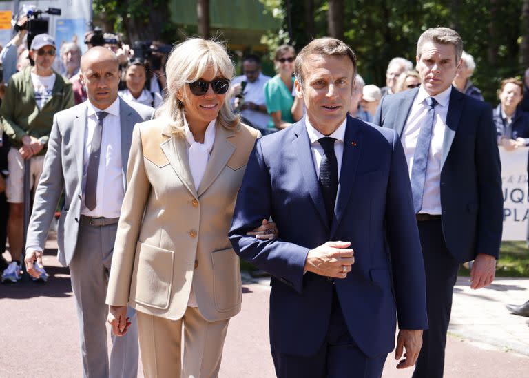 El presidente de Francia, Emmanuel Macron, y su esposa Brigitte Macron salen después de votar en la primera ronda de las elecciones parlamentarias francesas en Le Touquet, norte de Francia, el domingo 12 de junio de 2022.
