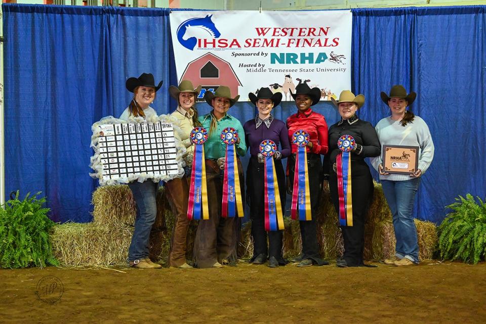 From left, Middle Tennessee State University equestrian team coach Ariel Higgins, riders Jordan Martin, Mackenzie Latimer, Simone Allen, Sadio Barnes, Monica Braunwalder and coach Andrea Rego are shown with their ribbons, first-place plaque and top eight finishers’ standings board after winning the Intercollegiate Horse Shows Association Western Semi-Finals March 22-23 at the Tennessee Livestock Center in Murfreesboro, Tenn. The team and seven individual riders qualified for the IHSA Nationals in Tryon, N.C., in early May, where they will defend the national championship the Blue Raider riders won in 2023.
