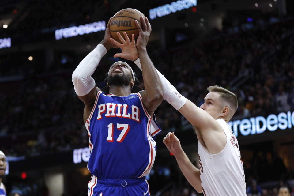 Philadelphia 76ers guard Buddy Hield (17) shoots against Cleveland Cavaliers guard Sam Merrill during the first half of an NBA basketball game Friday, March 29, 2024, in Cleveland. (AP Photo/Ron Schwane)