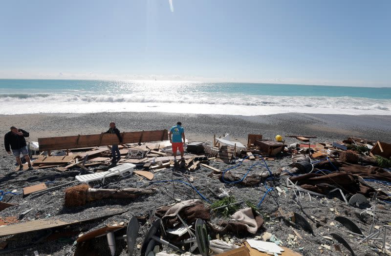 People are seen on a private beach following heavy rainfall in Nice