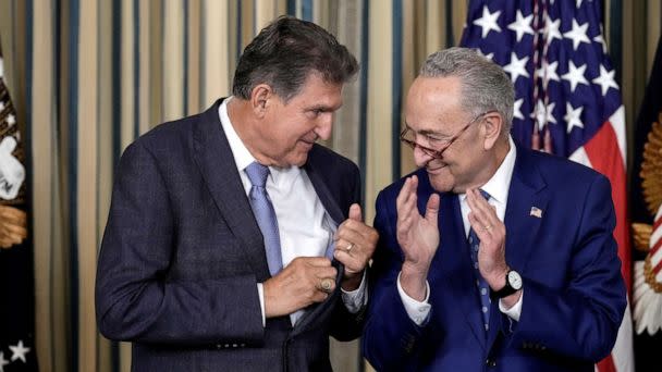 PHOTO: Sen. Joe Manchin looks to Senate Majority Leader Chuck Schumer after U.S. President Joe Biden signs The Inflation Reduction Act in the State Dining Room of the White House August 16, 2022 in Washington, DC. (Drew Angerer/Getty Images)