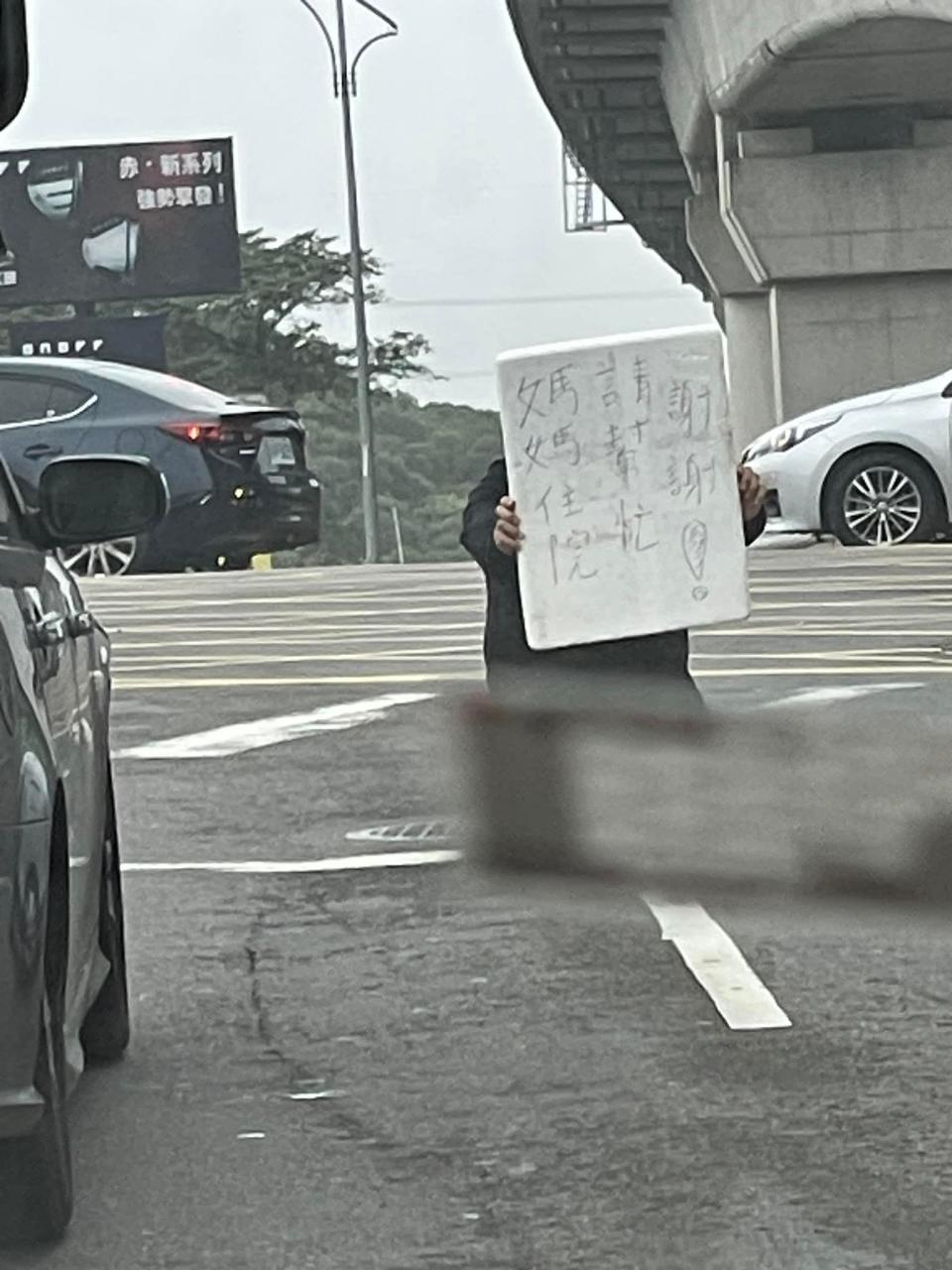 男子在路中央下跪舉牌，險象環生。（翻攝自林口大家庭LinKou-Family臉書）