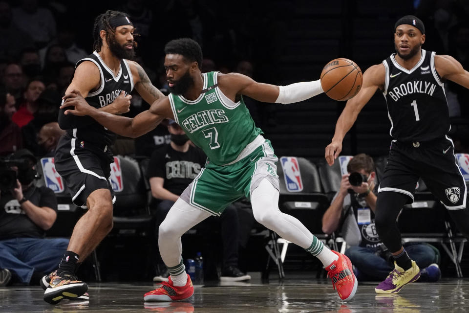 Boston Celtics guard Jaylen Brown (7) drives against Brooklyn Nets guard DeAndre' Bembry, left, during the first half of an NBA basketball game, Tuesday, Feb. 8, 2022, in New York. (AP Photo/John Minchillo)