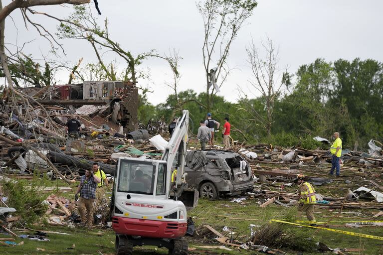Trabajadores buscan entre los restos de las casas dañadas por el tornado en Iowa.