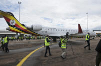 FILE - In this Tuesday, April 23, 2019 file photo, cameramen film at a ceremony to mark the arrival of two CRJ-900 jets from Canadian aerospace company Bombardier for Uganda's national carrier Uganda Airlines, at the airport in Entebbe, Uganda. Questions are swirling in Africa and elsewhere over the financial wisdom of sustaining prestige carriers that have a tiny share of an aviation market that sees no recovery in sight as sub-Saharan Africa faces its first recession in a quarter-century amid coronavirus-related travel restrictions. (AP Photo/Ronald Kabuubi, File)