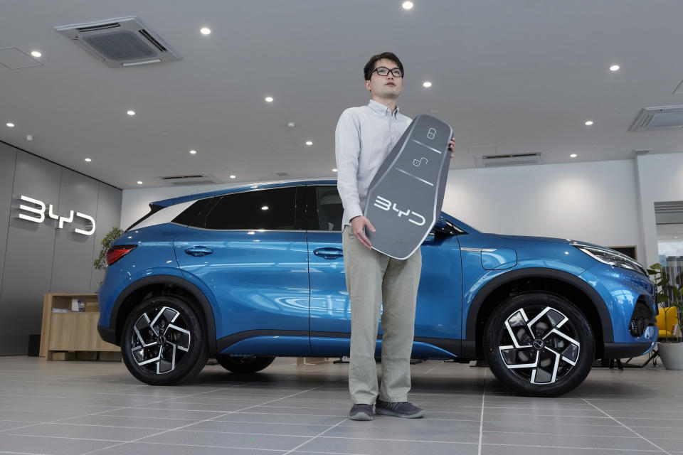 Ohta, who just bought a brand new BYD ATTO 3 electric sports utility vehicle, poses with his car and a symbolically-made key at a BYD dealership on April 4, 2023, in Yokohama near Tokyo. BYD Auto is part of a wave of Chinese electric car exporters that are starting to compete with Western and Japanese brands in their home markets. They bring fast-developing technology and low prices that Tesla Inc.'s chief financial officer says “are scary.” (AP Photo/Eugene Hoshiko)