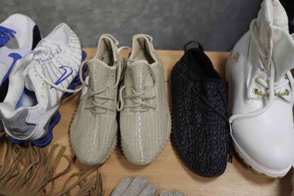 Seized counterfeit footwear, including copies of Adidas and Kanye West Yeezy Boost trainers, are displayed at U.K. Border Force offices in London in February 2017. (AP Photo/Matt Dunham)