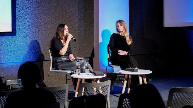 Mariana Savka (izquierda), escritora ucraniana, junto a Victoria Amelina, sentadas en una mesa durante una charla. 