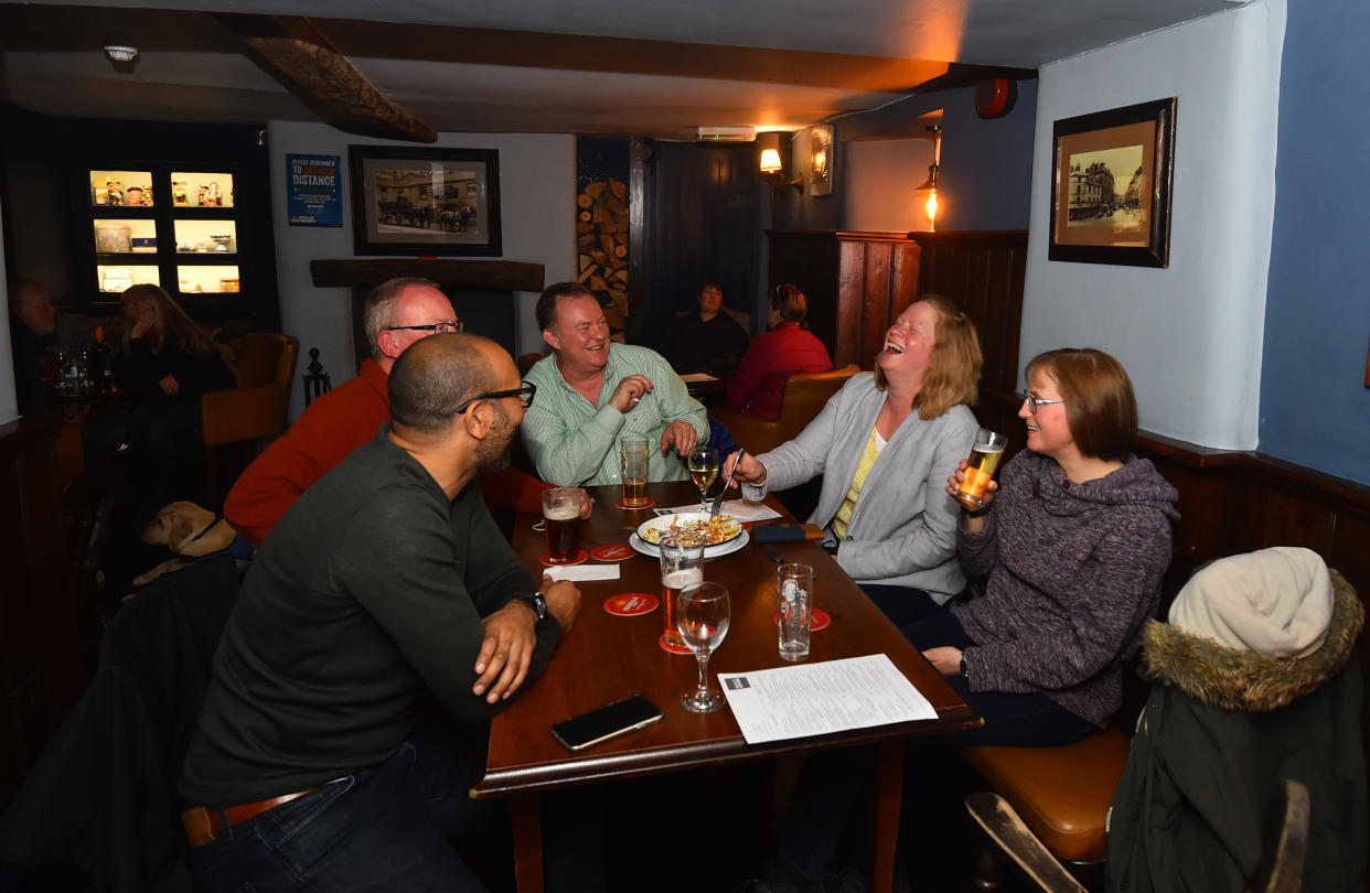 People socialize at the Old Sun Inn pub on May 17, 2021, in Buxton, England. (Nathan Stirk/Getty Images)