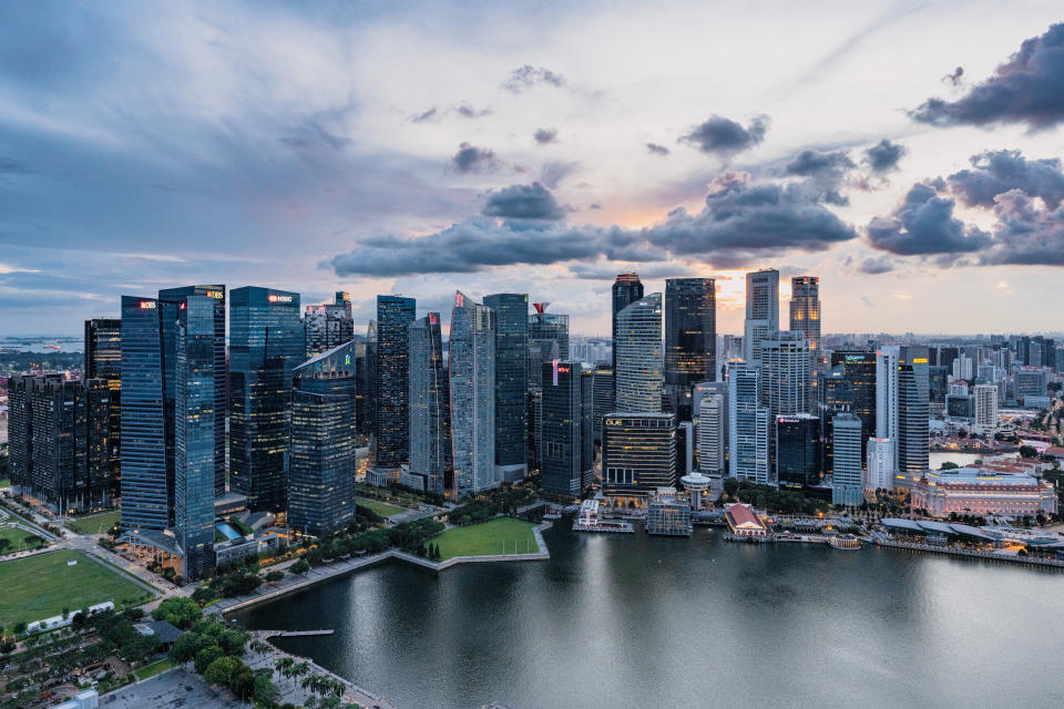 Financial center skyscraper buildings in the Marina Bay area of Singapore seen a cloudy sunset. Most of these skyscrapers are offices to large international banks.