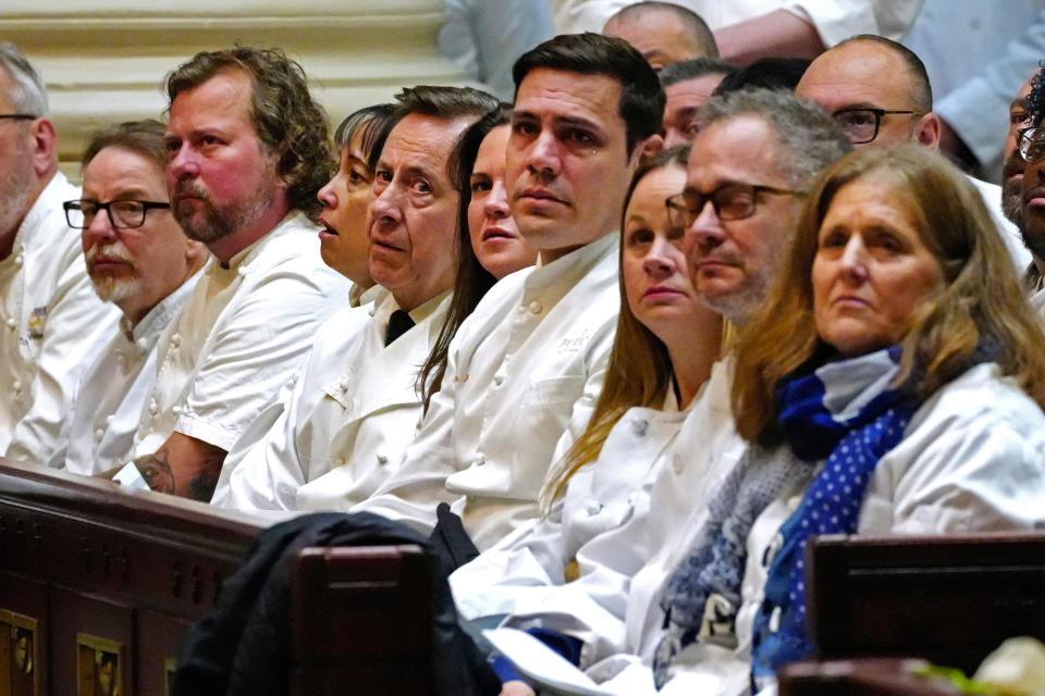 Chefs wear their white coats to honor Jean-Robert de Cavel, during his funeral at The Cathedral Basilica of Saint Peter in Chains in downtown Cincinnati, Monday, Jan. 16, 2023. In attendance was renowed chef Daniel Boulud, sixth from right, who encouraged de Cavel to take the Maisonette job back in 1993.
