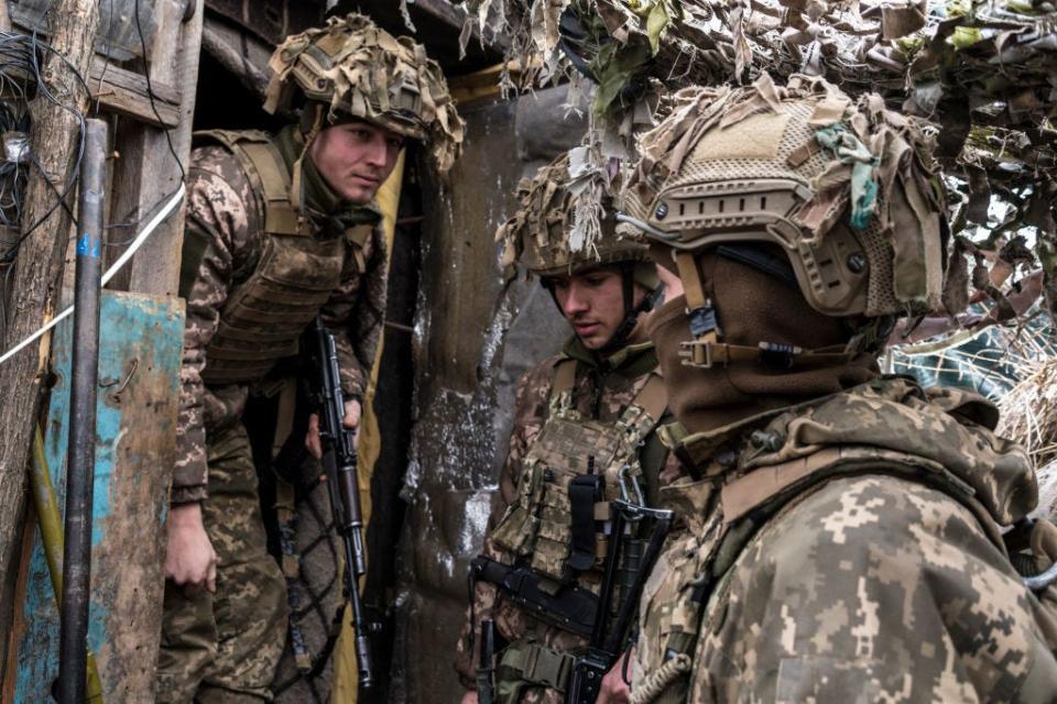 Ukrainian soldiers stand in a trench near the front line on January 17, 2022 in the village of New York, formerly known as Novhorodske, Ukraine