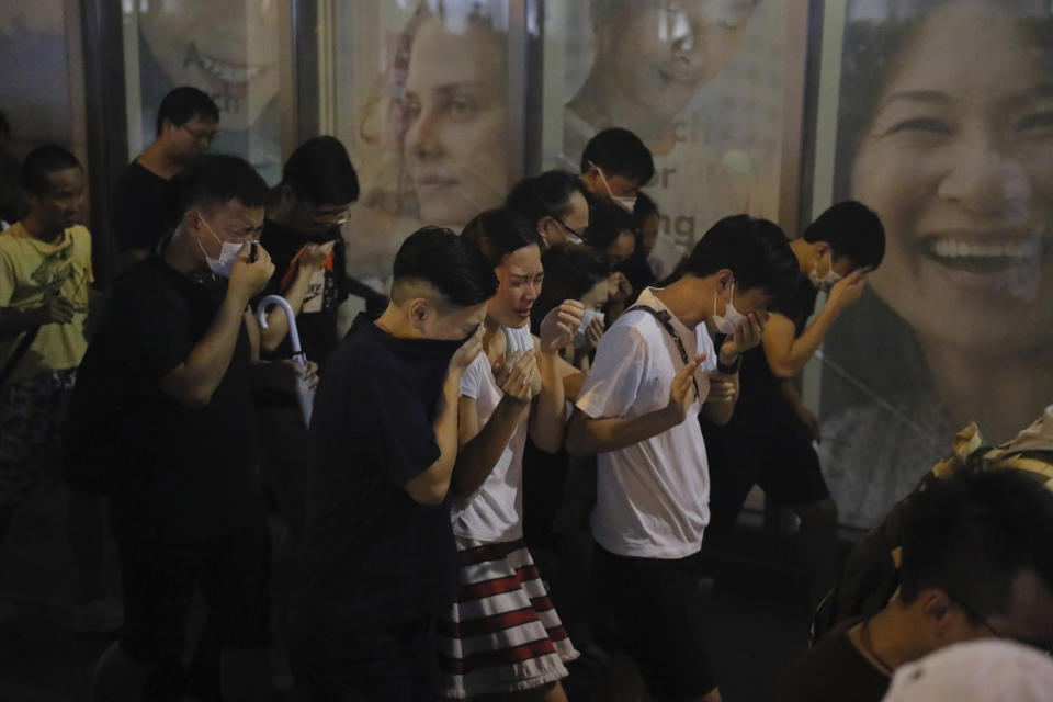 Residents react to tear gas during a confrontation in Hong Kong on Saturday, Aug. 10, 2019. Hong Kong is in its ninth week of demonstrations that began in response to a proposed extradition law but have expanded to include other grievances and demands for more democratic freedoms.(AP Photo/Kin Cheung)