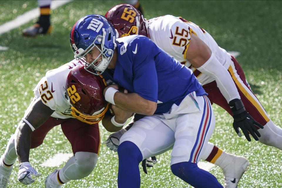 Washington Football Team's Deshazor Everett (22) and Cole Holcomb (55) tackle New York Giants quarterback Daniel Jones (8) during the second half of an NFL football game Sunday, Oct. 18, 2020, in East Rutherford, N.J. (AP Photo/John Minchillo)