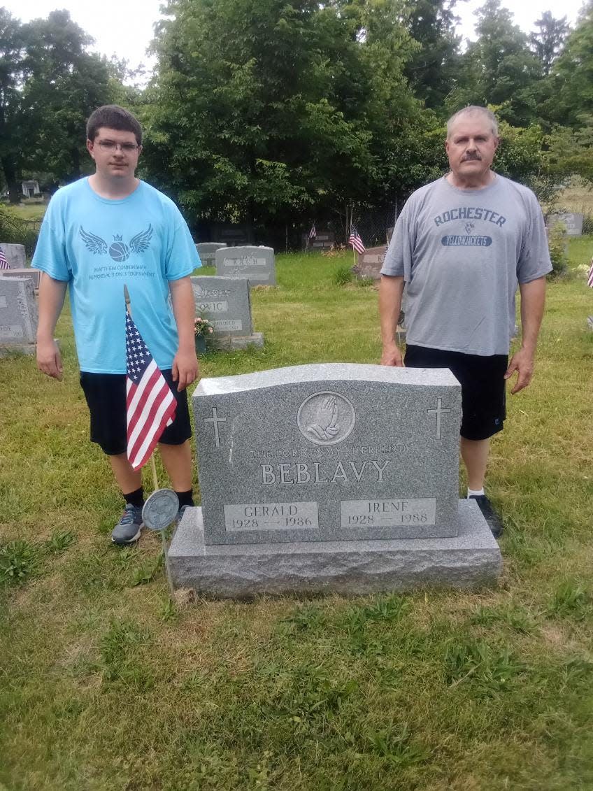 From left, John Beblavy and Robert Beblavy stand behind the gravestone of family members at the Slovak Lutheran Cemetery in Johnson City.