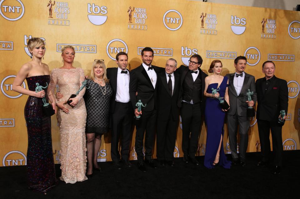 From left, Jennifer Lawrence, Elisabeth Rohm, Colleen Camp, Alessandro Nivola, Bradley Cooper, Robert De Niro, David O. Russell, Amy Adams, Jeremy Renner and Paul Herman pose in the press room with the award for outstanding performance by a cast in a motion picture for “American Hustle” at the 20th annual Screen Actors Guild Awards at the Shrine Auditorium on Saturday, Jan. 18, 2014, in Los Angeles. (Photo by Matt Sayles/Invision/AP)