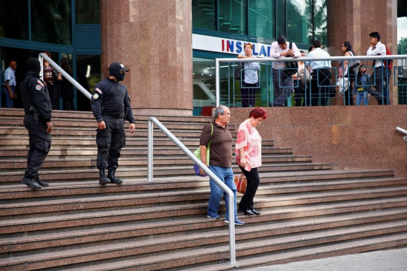 Members of Venezuela's state intelligence agency SEBIN stand outside the building containing the office of Venezuela's National Assembly President and opposition leader Juan Guaido, in Caracas