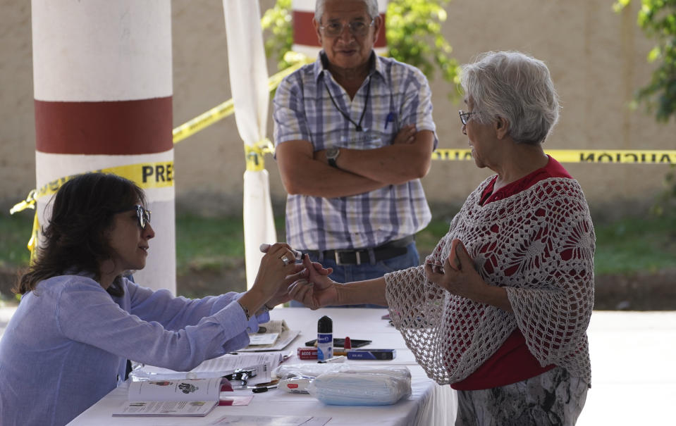 A woman has her thumb stained with ink after casting her ballot during local sate elections in Cuautitlán Izcalli, Mexico state, Mexico, Sunday, June 4, 2023. (AP Photo/Marco Ugarte)