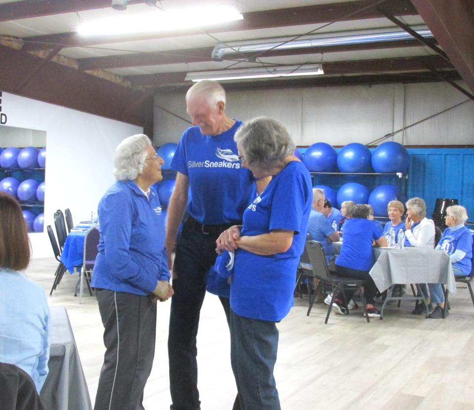 Ruth Ann Brenly visits with friends and fellow Silver Sneakers members Lonnie and Garnet Rogers during the Silver Sneakers Member of the Year ceremony held at Cheryl's L.I.F.E. Fitness in Mechanic Township.