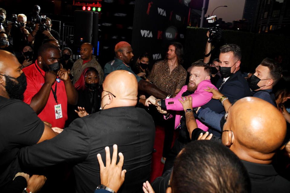 Conor McGregor being held back by several people at the VMAs red carpet. / Credit: Kevin Mazur/MTV VMAs 2021