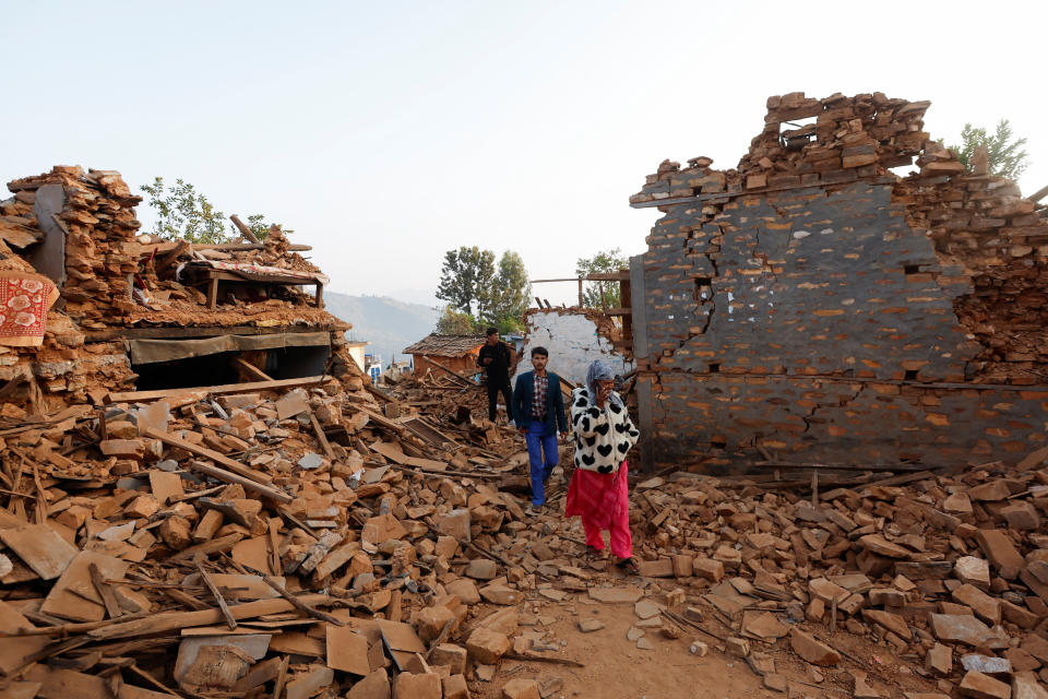 People walk on top of the debris from collapsed houses along streets in Jajarkot, Nepal November 5, 2023. REUTERS/Navesh Chitrakar