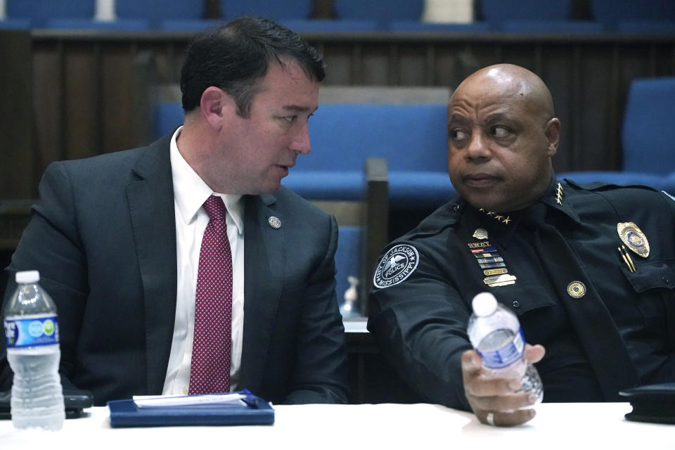 Mississippi Public Safety Commissioner Sean Tindell, left, confers with Jackson Police Chief James Davis during a town hall meeting to address youth crime issues in Jackson, Miss., Feb. 14, 2023. (AP Photo/Rogelio V. Solis)