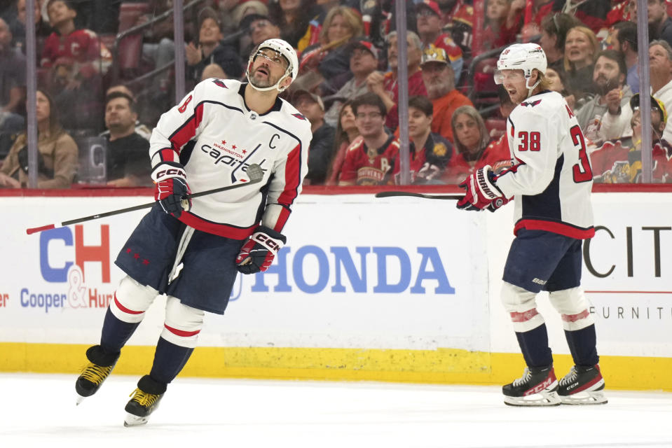 Washington Capitals left wing Alex Ovechkin (8) looks up at the scoreboard after scoring a power-play goal against the Florida Panthers as defenseman Rasmus Sandin (38) looks on during the first period of an NHL hockey game Thursday, Feb. 8, 2024, in Sunrise, Fla. (AP Photo/Jim Rassol)