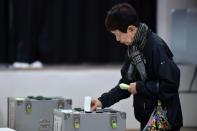 A woman casts her vote in Japan's general election at a polling station in Tokyo