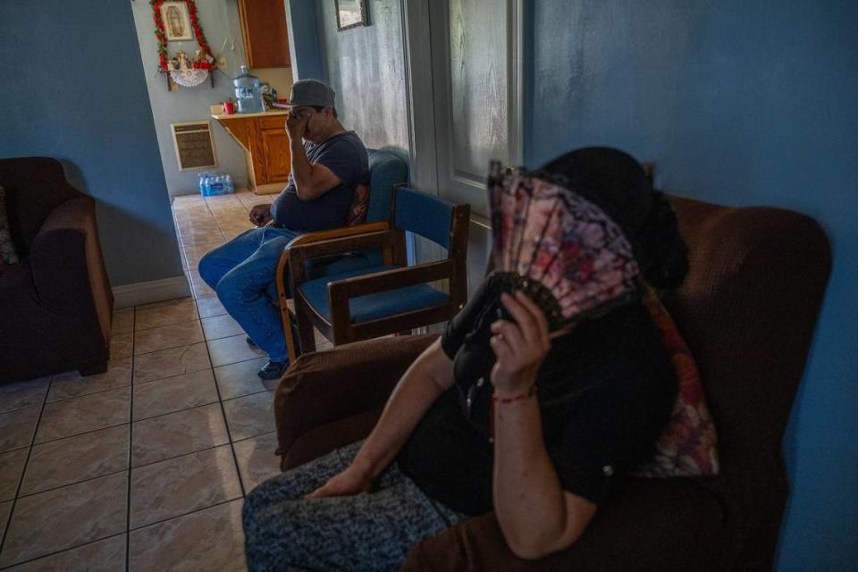 Maria Magaña gently uses her fan as her husband Pedro talks about the stress they’ve endured from the debilitating heat because they could not afford air-conditioning inside their living room in East Del Paso Heights on Tuesday. Pedro said he hopes state and local agencies respond more aggressively to climate change and helping the working poor through it.