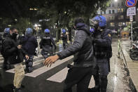 A police officer confronts a man during a protest against the government restriction measures to curb the spread of COVID-19, in Milan Italy, Monday, Oct. 26, 2020. Italy's leader has imposed at least a month of new restrictions to fight rising coronavirus infections, shutting down gyms, pools and movie theaters and putting an early curfew on cafes and restaurants. (AP Photo/Luca Bruno)