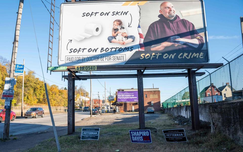 In Braddock, Pennsylvania, der Heimatstadt des Kandidaten für den demokratischen US-Senat, werden Schilder zur Unterstützung von John Fetterman und eine Plakatwand der Opposition angebracht – BRANDEN EASTWOOD /AFP über Getty Images