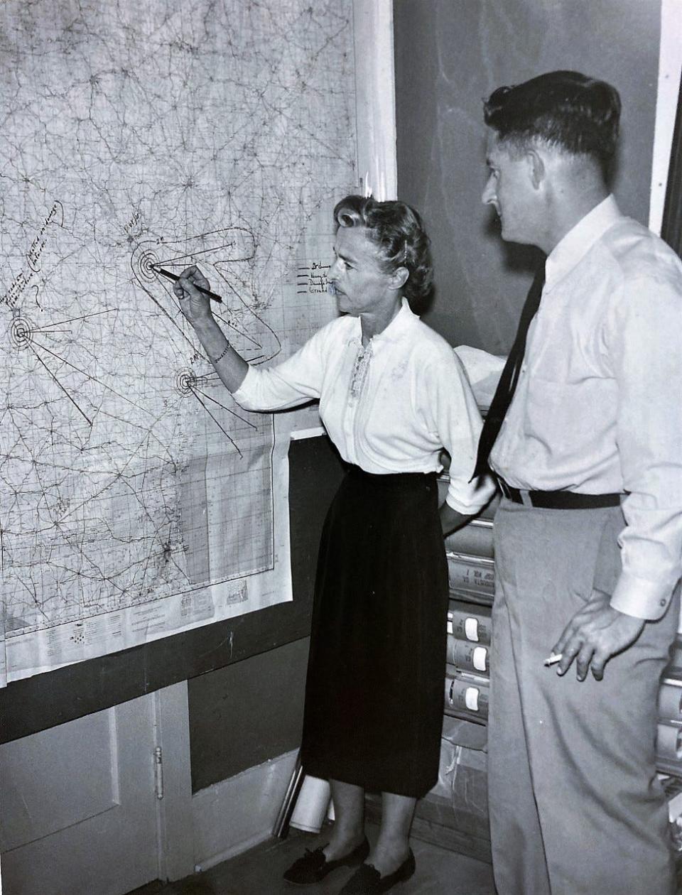 Civil Defense Director Lillian Freiberg makes a point as Capt. Barney Nobles, of the Army National Guard, looks  on