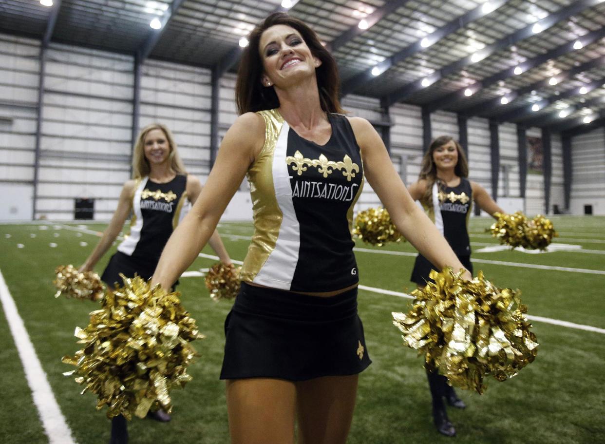 Kriste Lewis realiza una rutina con dos compañeras durante una sesión fotográfica del equipo de porristas Saintsations, en las instalaciones de los Bengals de Cincinnati en Metairie, Louisiana. (Foto AP/Bill Haber)