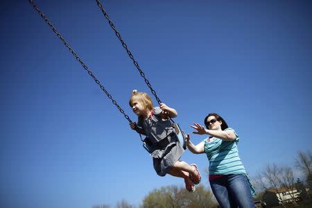 Andrea Smith plays with her daughter Norah at a playground in Winthrop Harbor, Illinois, May 9, 2014. REUTERS/Jim Young