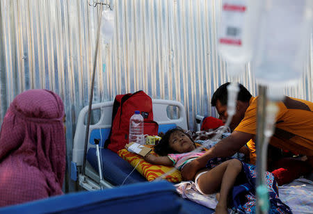 A father accompanies his injured child outside of Tanjung hospital, after an earthquake hit in Lombok Utara, Indonesia August 6, 2018. REUTERS/Beawiharta