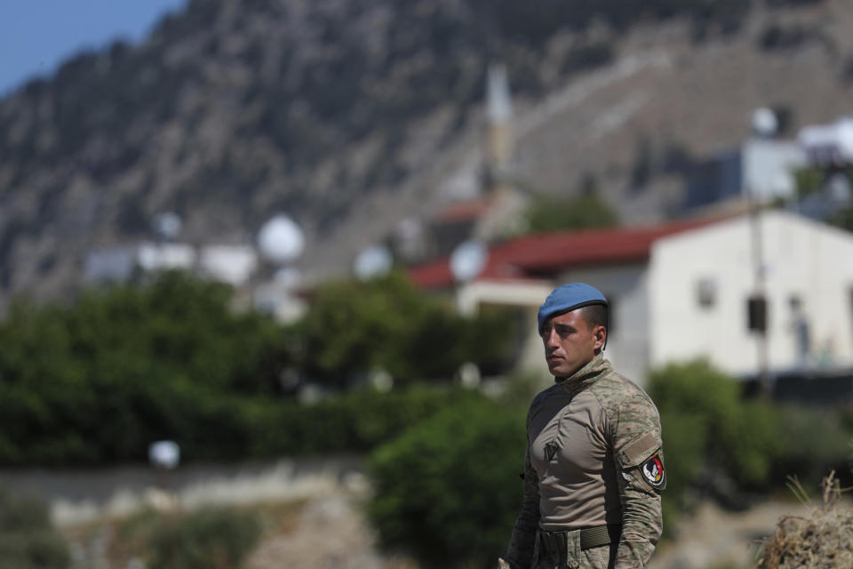 A Turkish commando stands guard in the area after an explosion pre-dawn, outside of the village of Tashkent in Turkish Cypriot breakaway north part of the divided Cyprus, Monday, July 1, 2019. A Turkish Cypriot official said Monday that a Syrian anti-aircraft missile that missed its target and reached ethnically divided Cyprus may have been the cause of an explosion outside a village in east Mediterranean island notion's breakaway north. No injuries were reported. (AP Photo/Petros Karadjias)