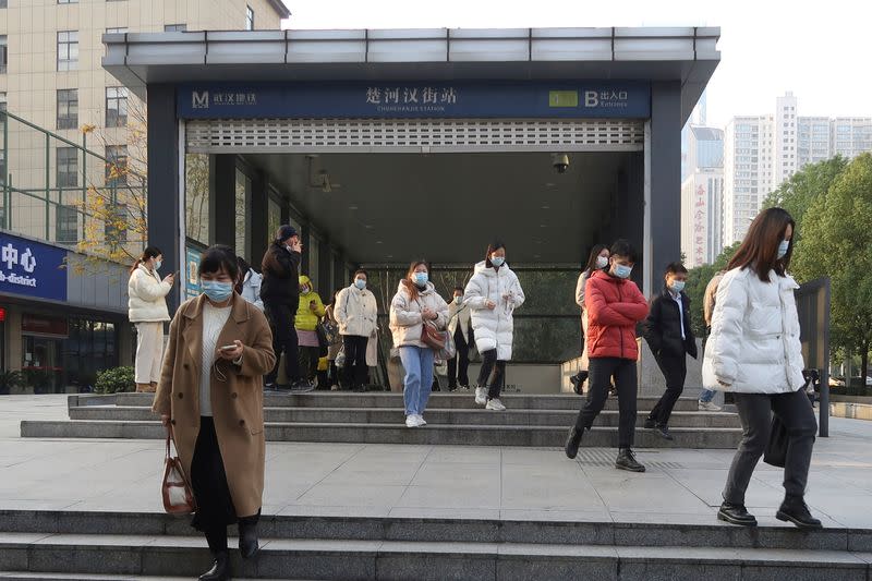 People walk out of a subway station during morning rush hour in Wuchang district, after the government gradually loosened restrictions on COVID-19 control, in Wuhan, Hubei