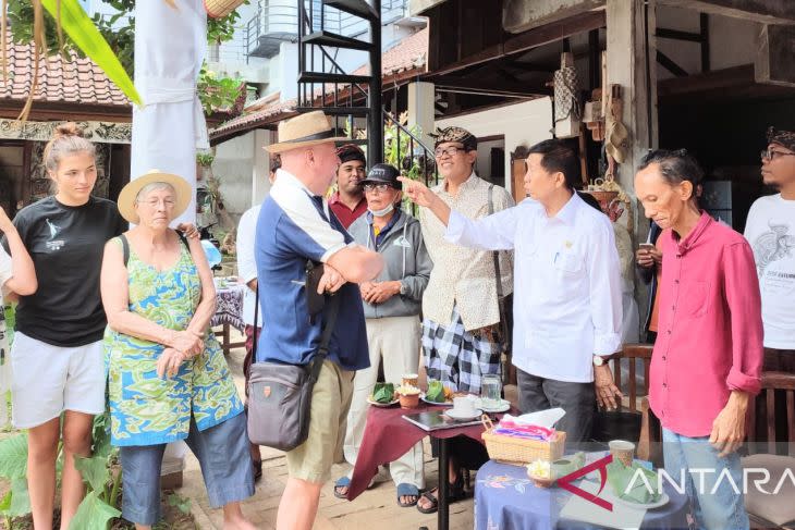 Anggota Dewan Perwakilan Daerah Dapil Bali Made Mangku Pastika saat berbincang dengan sejumlah wisatawan di bengkel kerja pelukis Made "Kaek" Dharma Susila di Sukawati, Gianyar, Rabu (27/7/2022). ANTARA/Ni Luh Rhismawati.