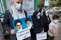 Iraníes exhiben retratos de líderes iraníes, entre ellos el líder supremo Ali Jamenei, frente a una mesa electoral en Teherán el 18 de junio de 2021