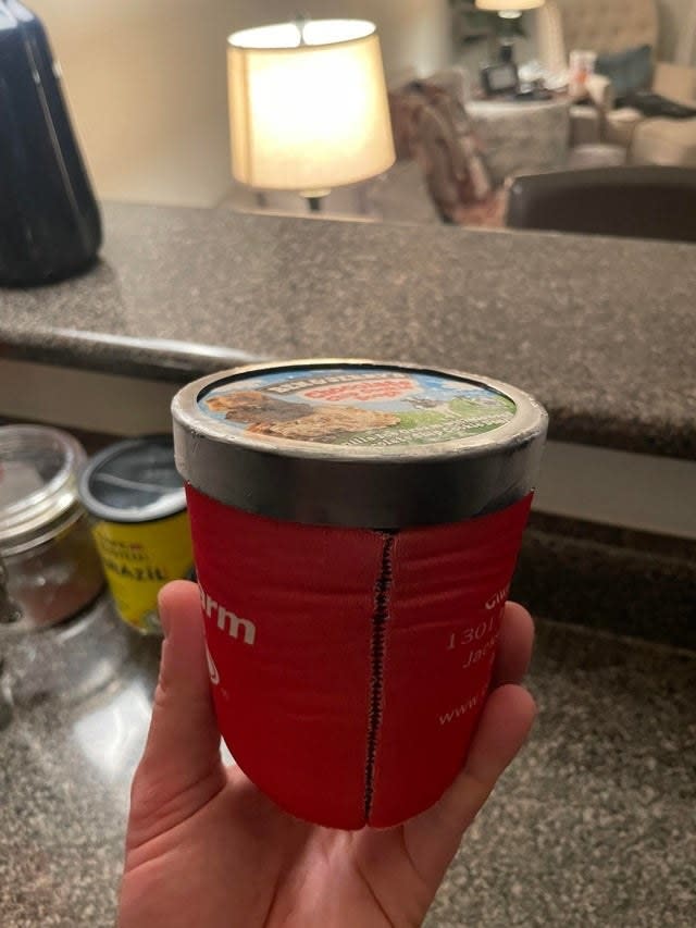 A pint of ice cream in a koozie.