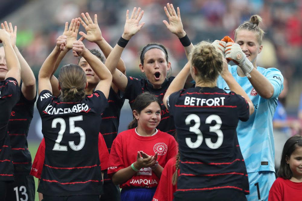 Portland Thorns cheer after the national anthem is played before a match