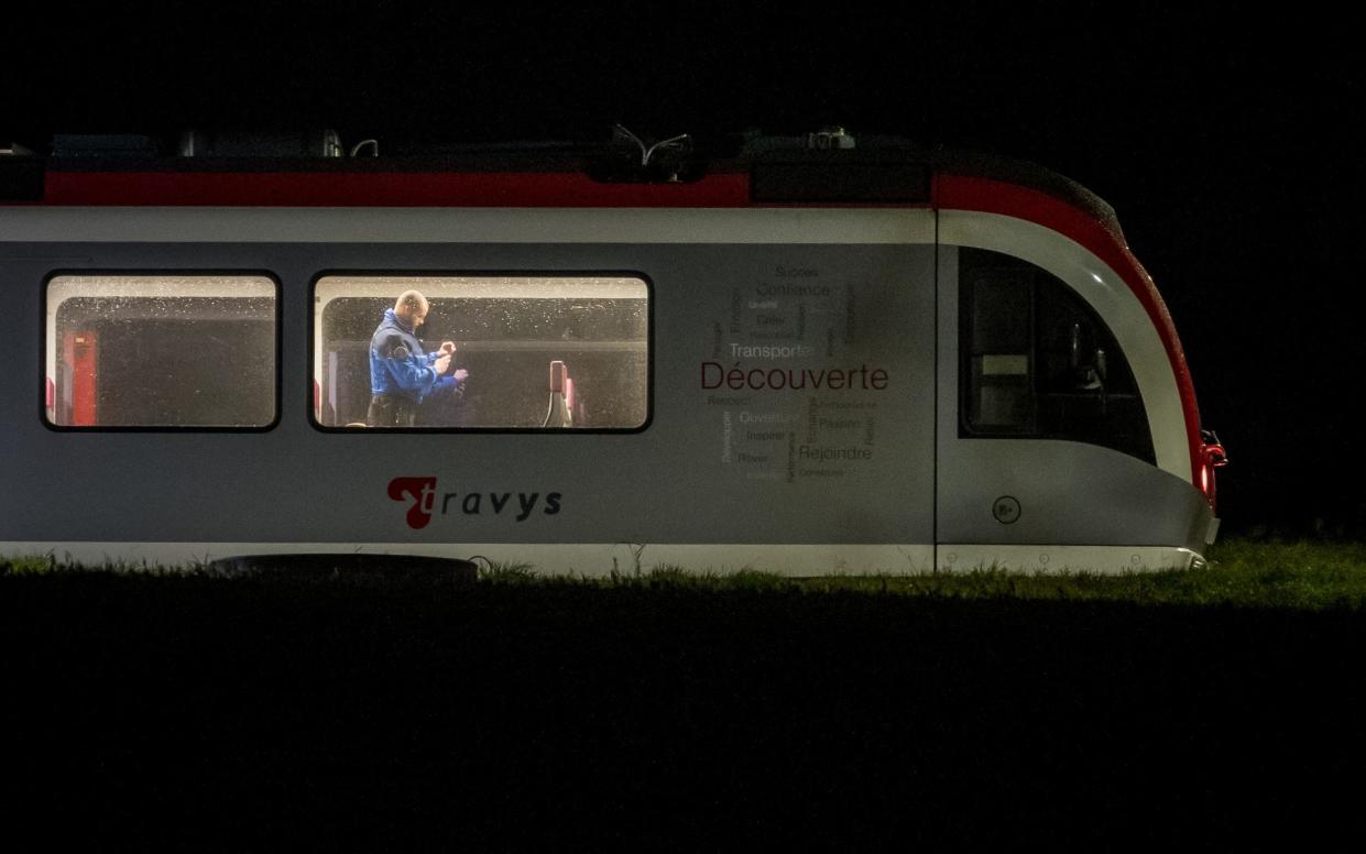 A Swiss Police officer inspects the inside of a train, where passengers travelling from Yverdon to Sainte-Croix were earlier held hostage, in Essert-Sous-Champvent, western Switzerland, on February 8, 2024.