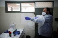 Yakov Kurtz, who works for Chevra Kadisha, the main group overseeing Jewish burials in Israel, adjusts his protective gear at a special centre that prepares bodies of Jews who died from the coronavirus disease (COVID-19) in Tel Aviv