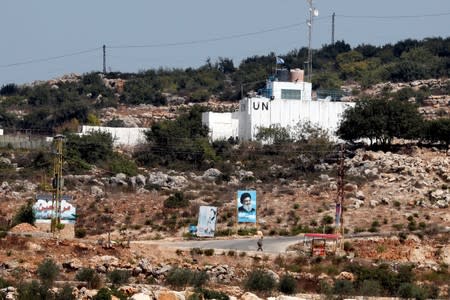 FILE PHOTO: A banner depicting Hezbollah leader Sayyed Hassan Nasrallah and an United Nation's post are seen in Lebanon from the Israeli side of the border, near Zar'it in northern Israel