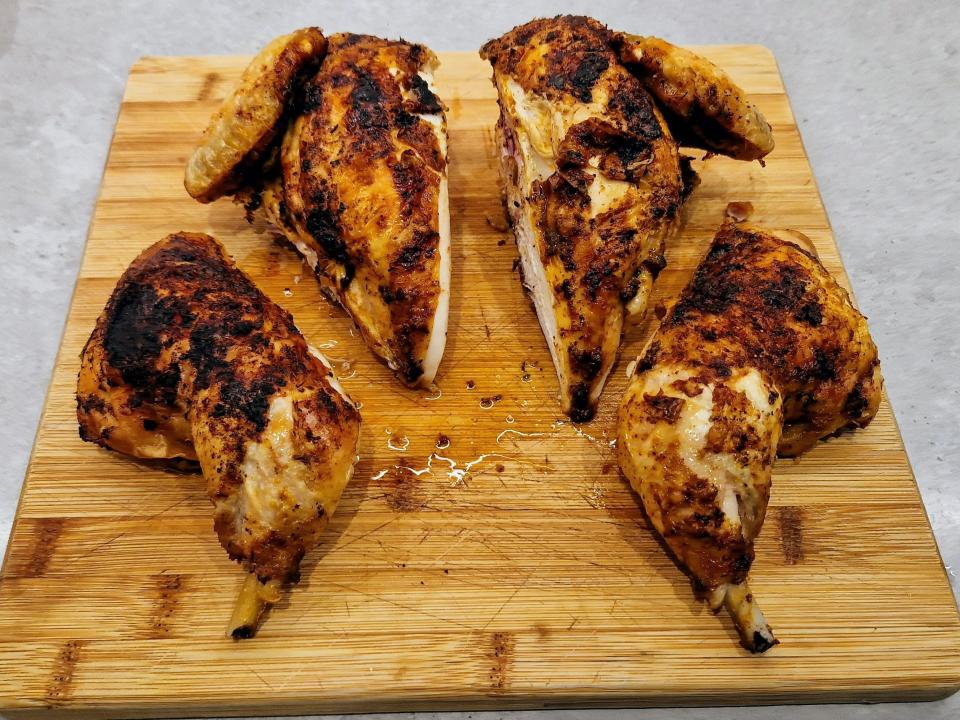 a whole chicken cut up into four portions on a cutting board
