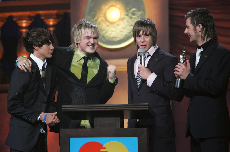 LONDON - FEBRUARY 9: Members of McFly (L-R) Dougie Poynter, Tom Fletcher, Danny Jones and Harry Judd receive the award for 'Best Pop Act' at the 25th Anniversary BRIT Awards 2005 at Earl's Court February 9, 2005 in London. (Photo by Dave Hogan/Getty Images)