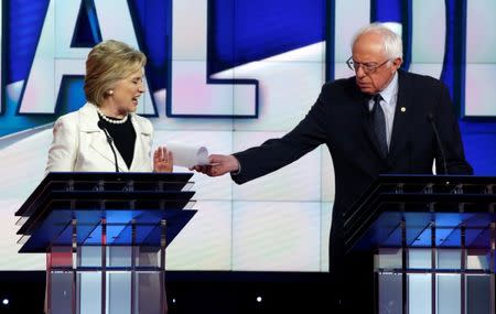 Hillary Clinton reacts as Bernie Sanders tries to hand her a piece of paper during a debate at the Brooklyn Navy Yard. REUTERS/Lucas Jackson